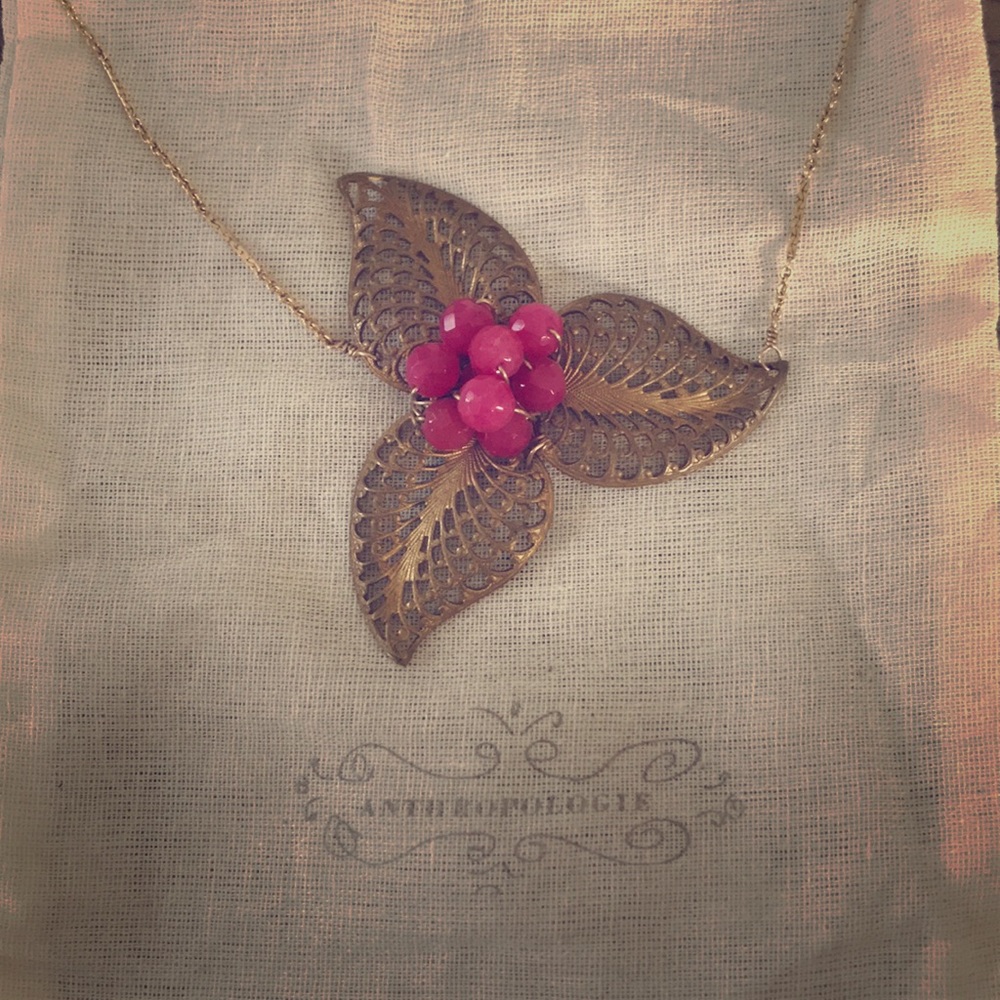 Delicate gold necklace with pink center stone.
